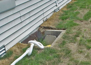 The ugly, old concrete window well of a Elmira crawl space