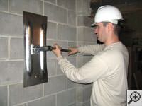 Attempting to straighten a bowed foundation wall by straightening a wall anchor system in a Newfield home.