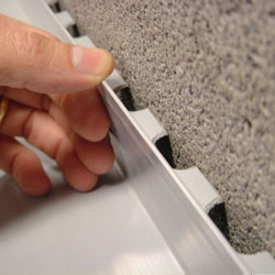 A contractor in Windsor installing a perimeter drain tile system during a sump pump installation.