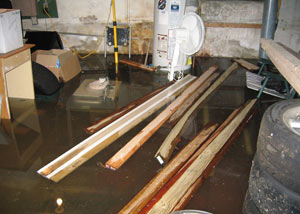 A severely flooding basement in Newfield, with lumber and personal items floating in a foot of water